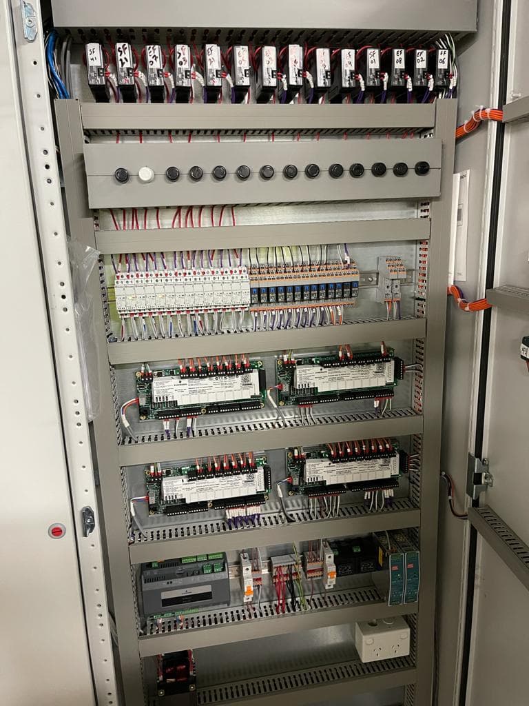 BMS control panel with neatly arranged modules, wiring, and circuit protection
