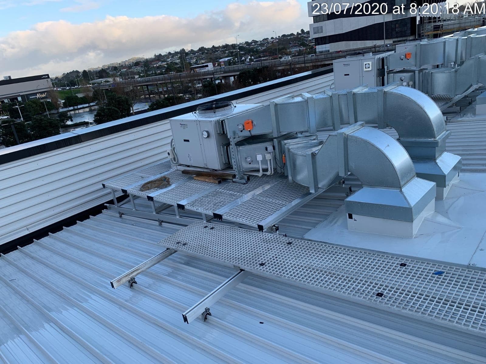 Rooftop HVAC ductwork and air handling unit installed on a service platform