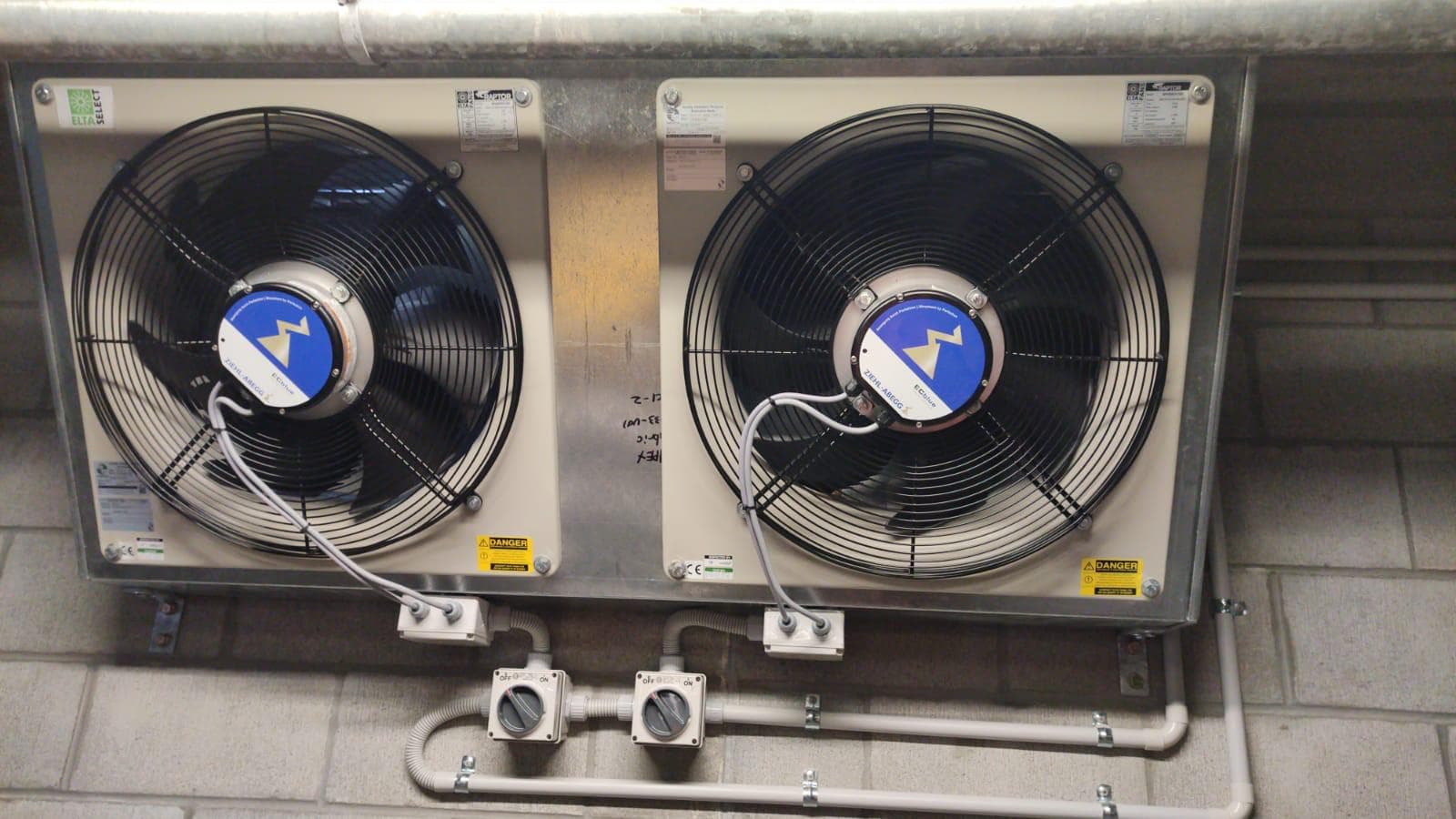 Twin commercial fans with electrical isolators and conduit installed below