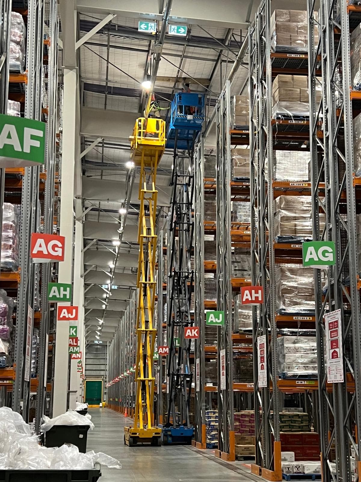 HVAC Controls Ltd technicians working from elevated platforms inside a commercial warehouse